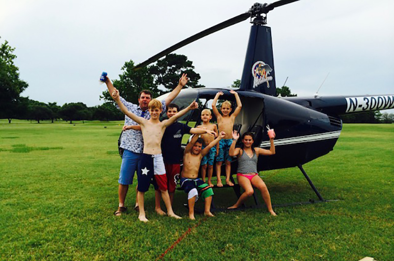 Kids pose in front of helicopter